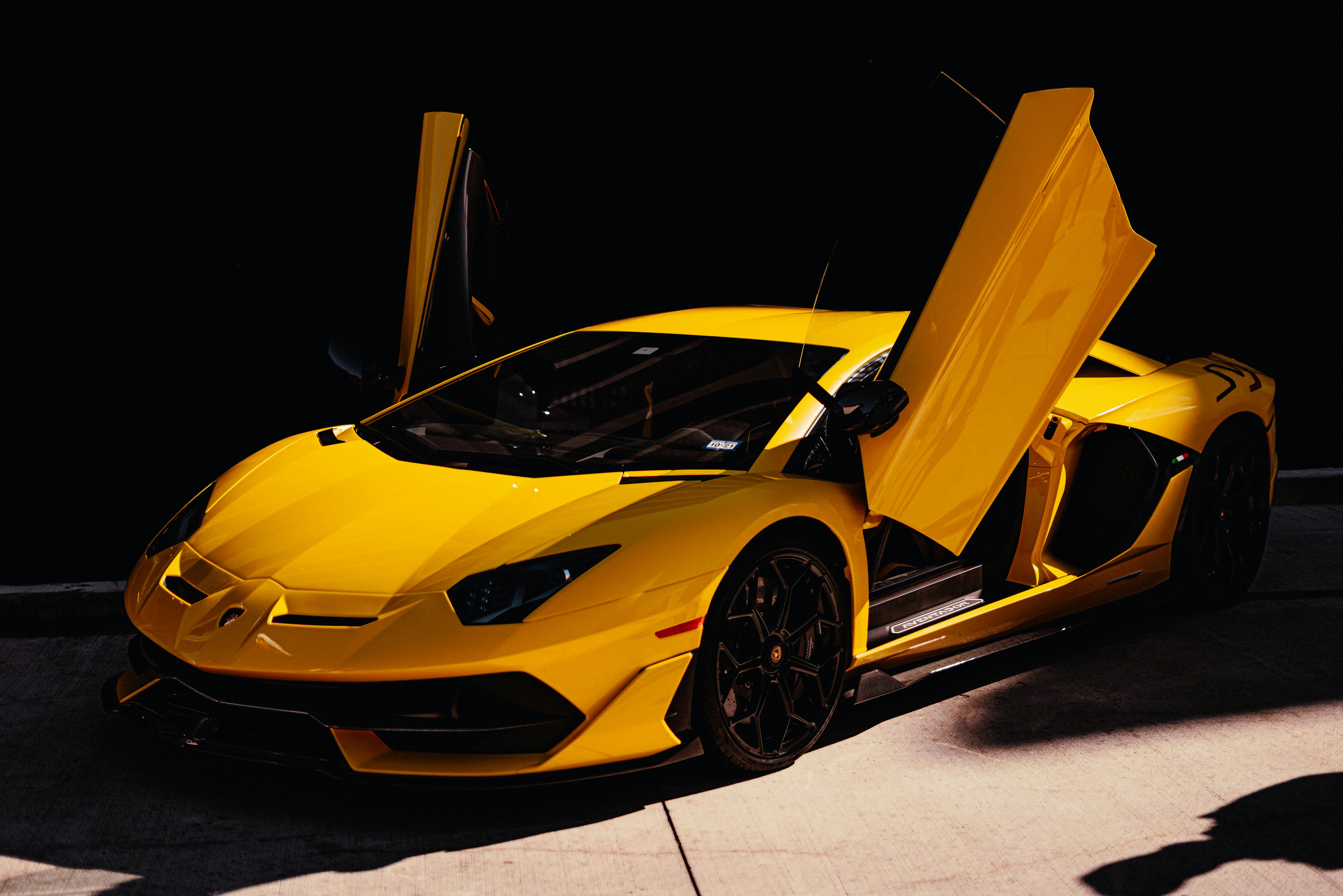 Gelber Lamborghini Aventador mit geöffneten Scherentüren bei einer Automobilausstellung