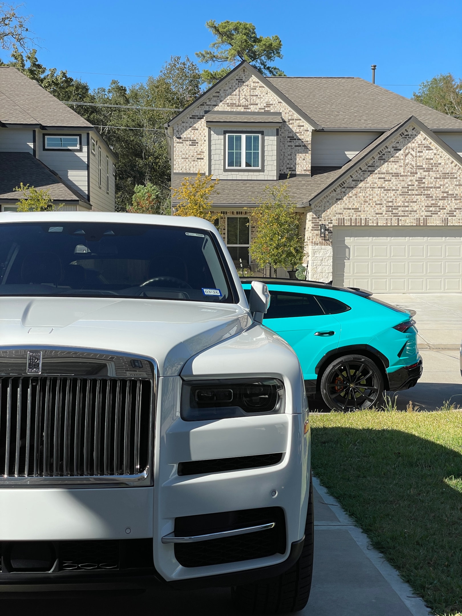 Rolls-Royce SUV und Lamborghini Urus vor moderner Villa in Wohngegend – exklusive Luxusautos für Premium- und Sportwagenmiete über Drivable, ideal für besondere Anlässe, Reisen und High-End-Erlebnisse.